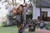 High quality a woman photographer is wearing a leather backpack  in Africa and her son is running towards her.