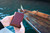 High quality closed lifestyle image of the passport leather sleeve in reddish brown