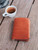 This is the closed lifestyle image of the passport sleeve in tan