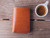High quality closed lifestyle image of the passport leather sleeve in tan