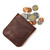 High quality red brown leather coin purse that has change spilling out of the pouch.
