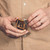 High quality front of a tan brown leather coin purse used for change that a man is holding.