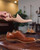 High quality wooden shoe tree held in profile above a brown leather wingtip shoe - Saddleback Leather