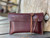 High quality red brown leather wallet bag with passports and yellow cards in it standing up.