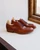 High quality red brown full grain leather wing tip shoes side profile on windowsill showing welt stitching and shoe trees - Saddleback Leather