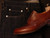 High quality red brown full grain leather wing tip shoe side profile flat lay with dark raw selvedge denim - Saddleback Leather