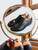 High quality black full grain leather wing tip shoes elevated top-down view with wooden shoe trees and brass mirror - Saddleback Leather
