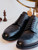 High quality close-up of black full grain leather wing tip shoes front angle showing vamp laces and brogue perforations - Saddleback Leather