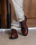 High quality dark oak full grain leather toe cap shoes front view with ankles crossed showing brogue detail - Saddleback Leather