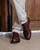 High quality dark oak full grain leather toe cap shoes front view with ankles crossed showing brogue detail - Saddleback Leather