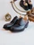 High quality black full grain leather toe cap shoes studio three-quarter front view with wooden shoe trees and vanity mirror - Saddleback Leather