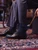 High quality black full grain leather toe cap shoe side angle with shoe horn showing heel and sole profile on oriental rug - Saddleback Leather