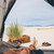 High quality tan brown leather duffle bag outside of a tent in the sand.