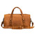 High quality tan brown leather duffle bag that has three straps to close it and has two round handles from the back.