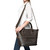 This is the view of the leather zipper tote in dark brown leather with a model wearing it crossbody