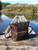 High quality this dark brown women's leather backpack is on a dock in Canada near Tofino and is showing the front angle.