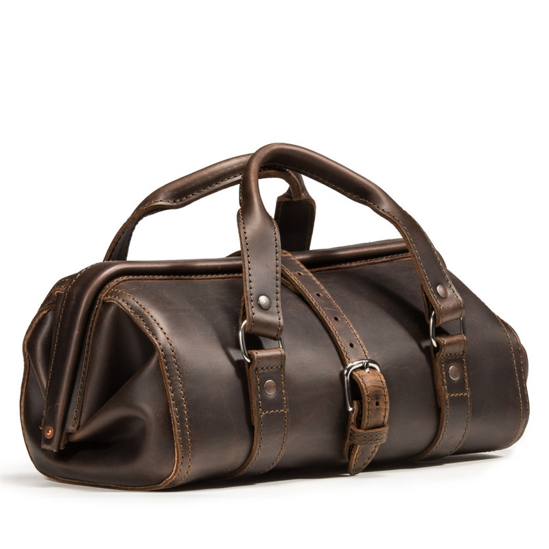 This dark brown leather doctor's leather tool bag is in a woodshop.