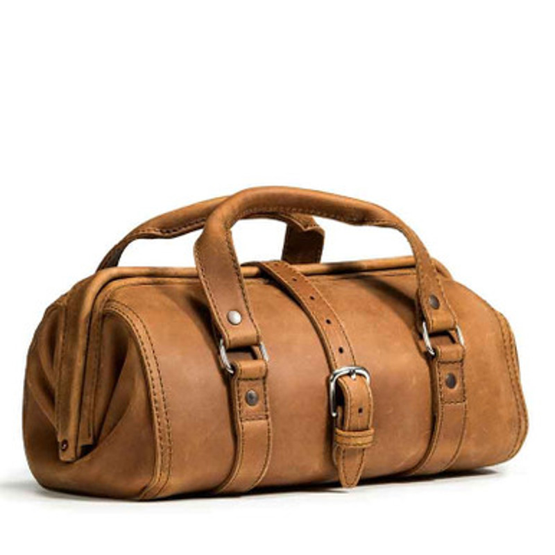 This dark brown leather doctor's leather tool bag is in a woodshop.