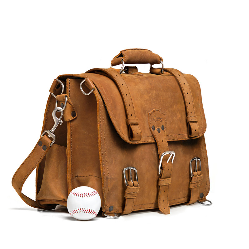 This is a tan full grain leather briefcase in side view with baseball