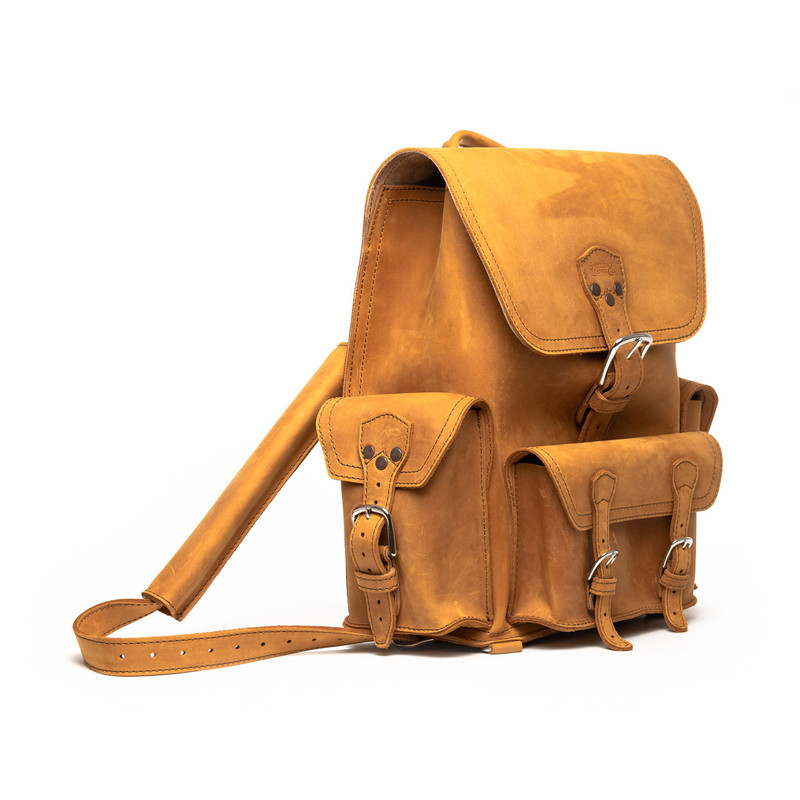 This is a tan brown leather backpack with three pockets on the outside. The image of this backpack is the front side.