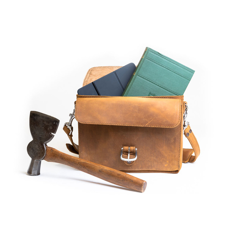 High quality front side of a tan brown leather satchel with a front pocket empty.