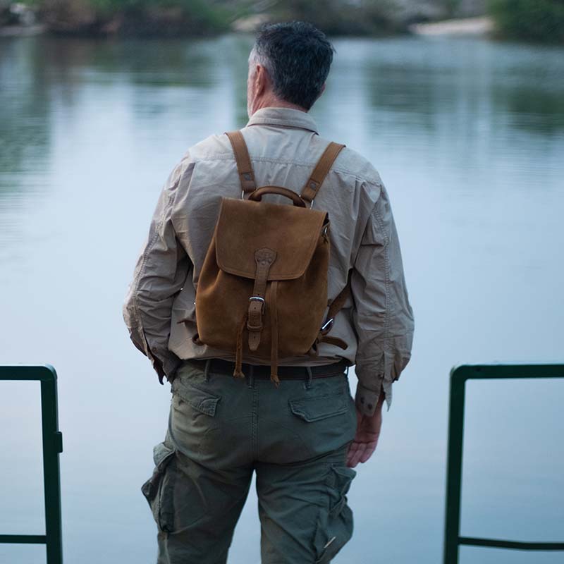 The 12" Full Grain Leather Drawstring Backpack is designed with simplicity and functionality in mind, featuring a wide opening, pigskin-lined back, laptop pocket, and adjustable shoulder straps.