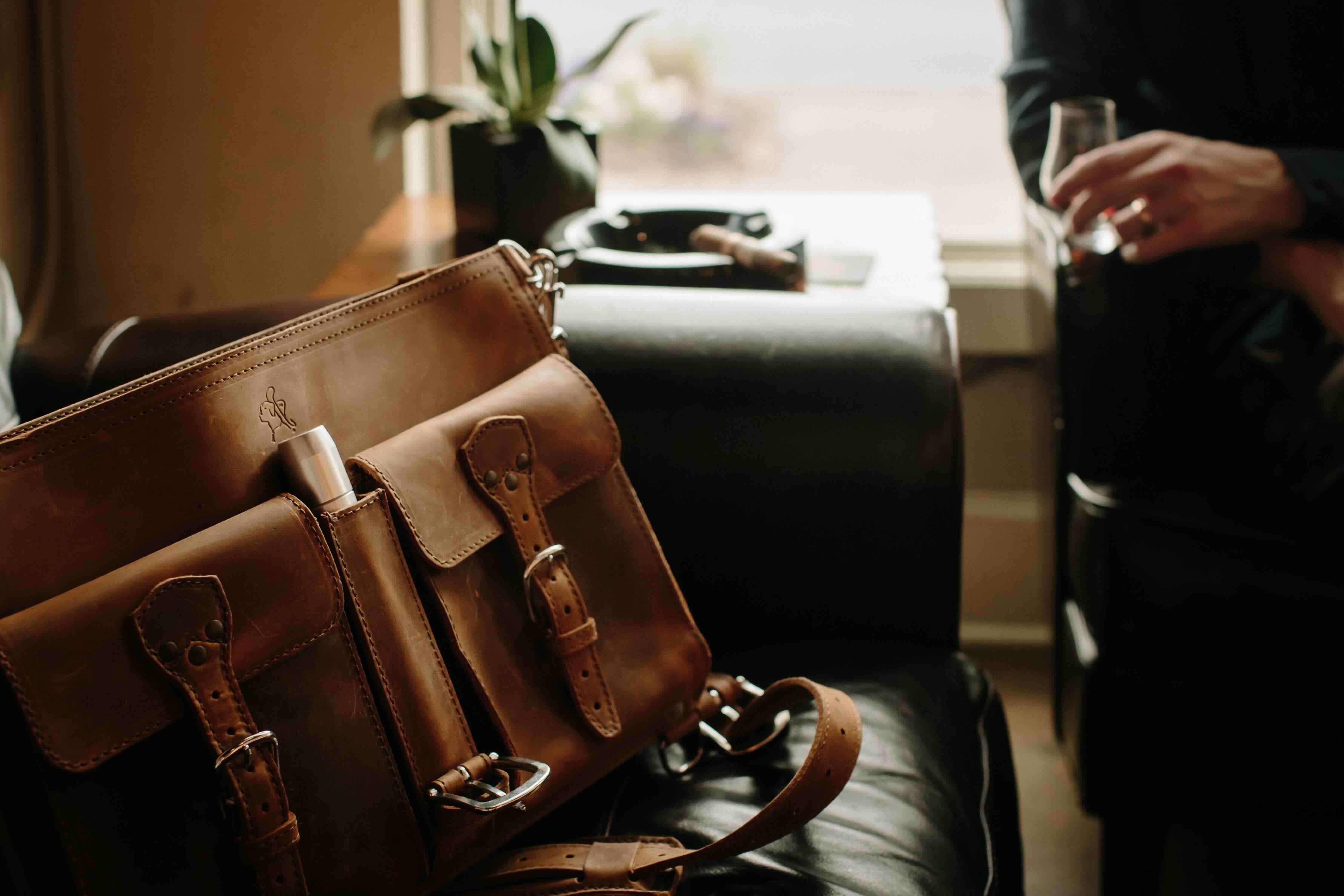 A leather briefcase with front pockets and a cigar holder.
