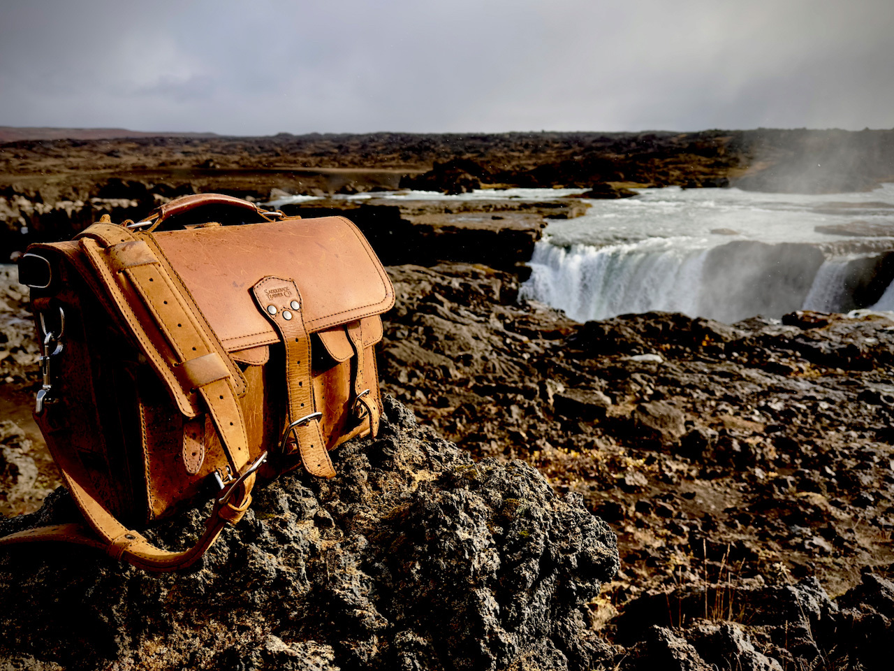 Full grain leather briefcase in front of a waterfall.