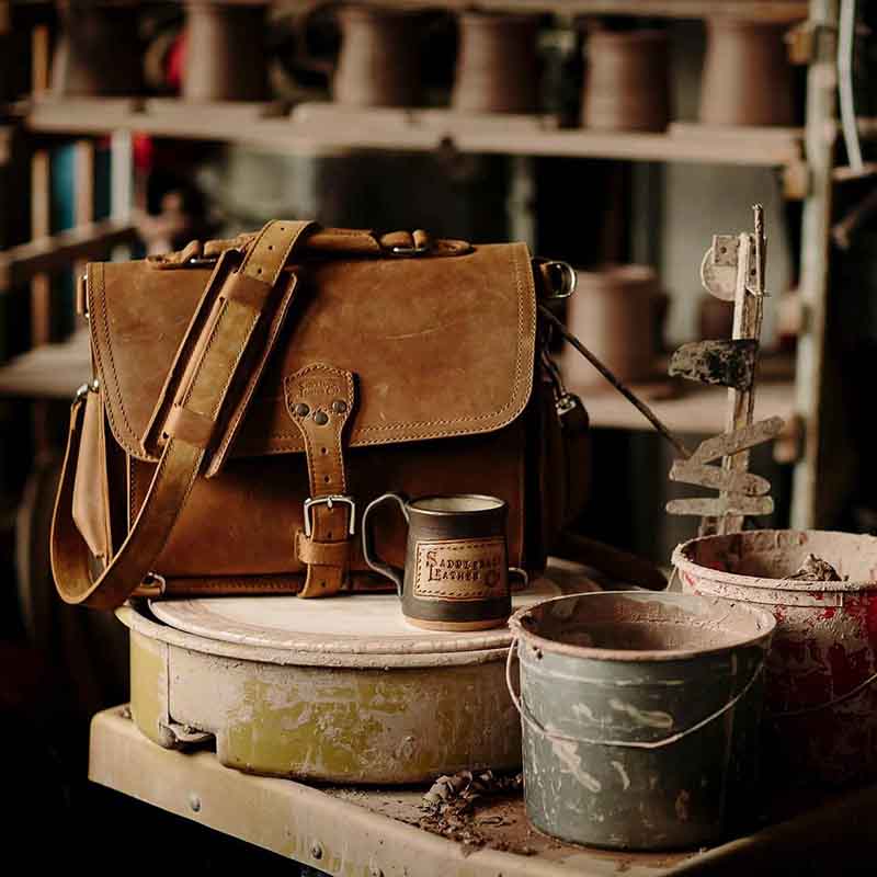 This leather briefcase has many features, including device pockets, interior pockets, and a side pocket for a water bottle.