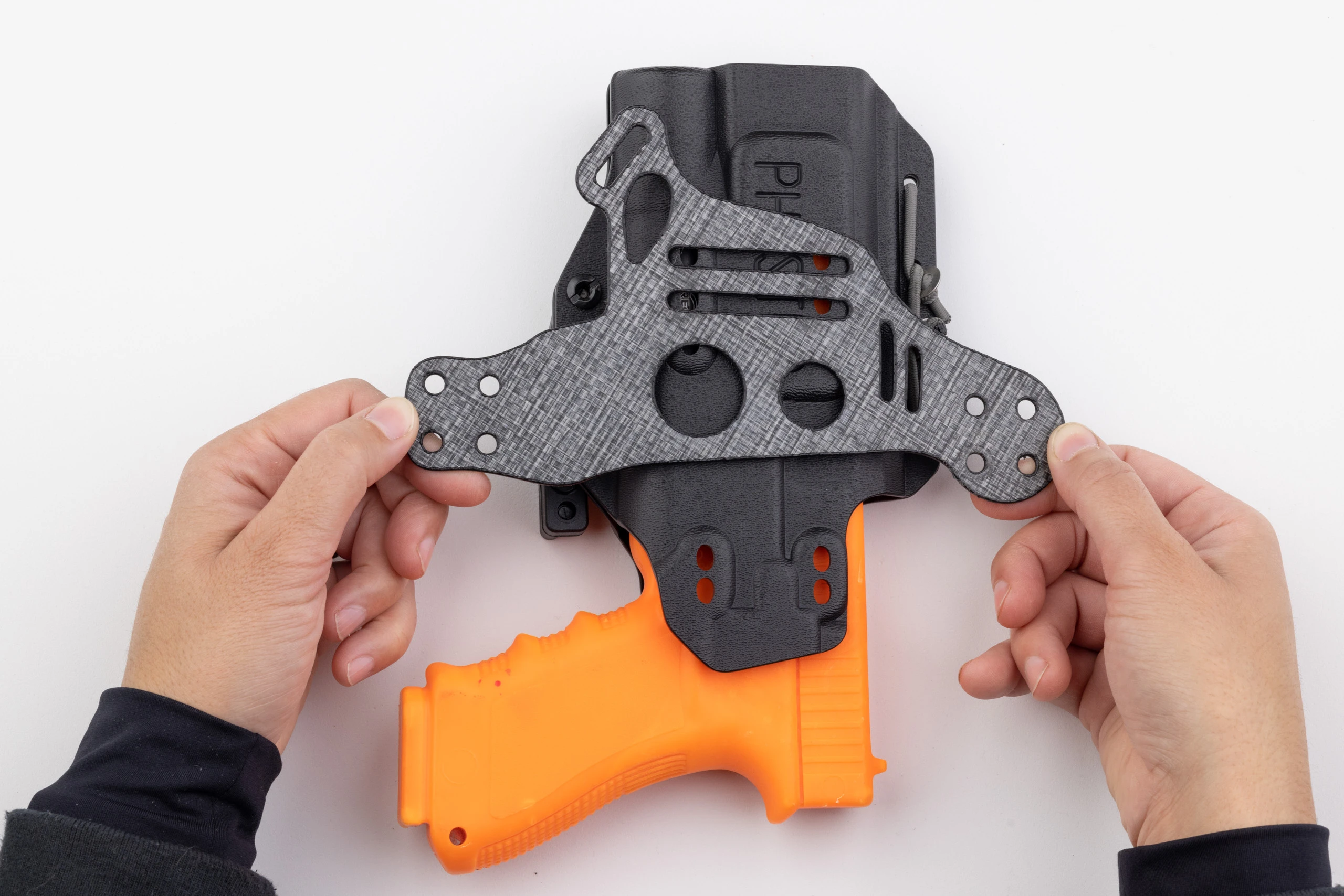 Photo of Light Bearing Enigma faceplate sitting on top of holster.