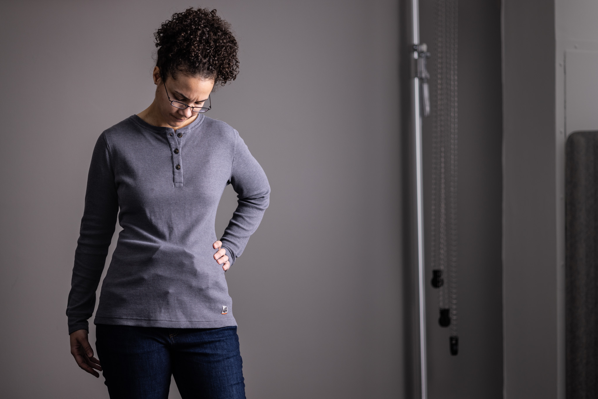 Woman performing a concealment check by feeling along her waistline to verify her holster is not printing