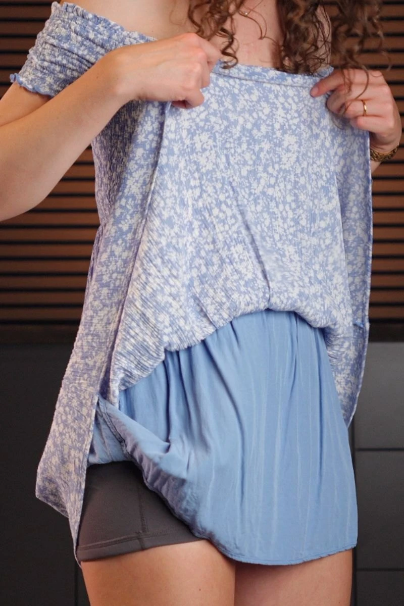 A dress lifted to show the built-in slip layer and the shorts worn underneath it.