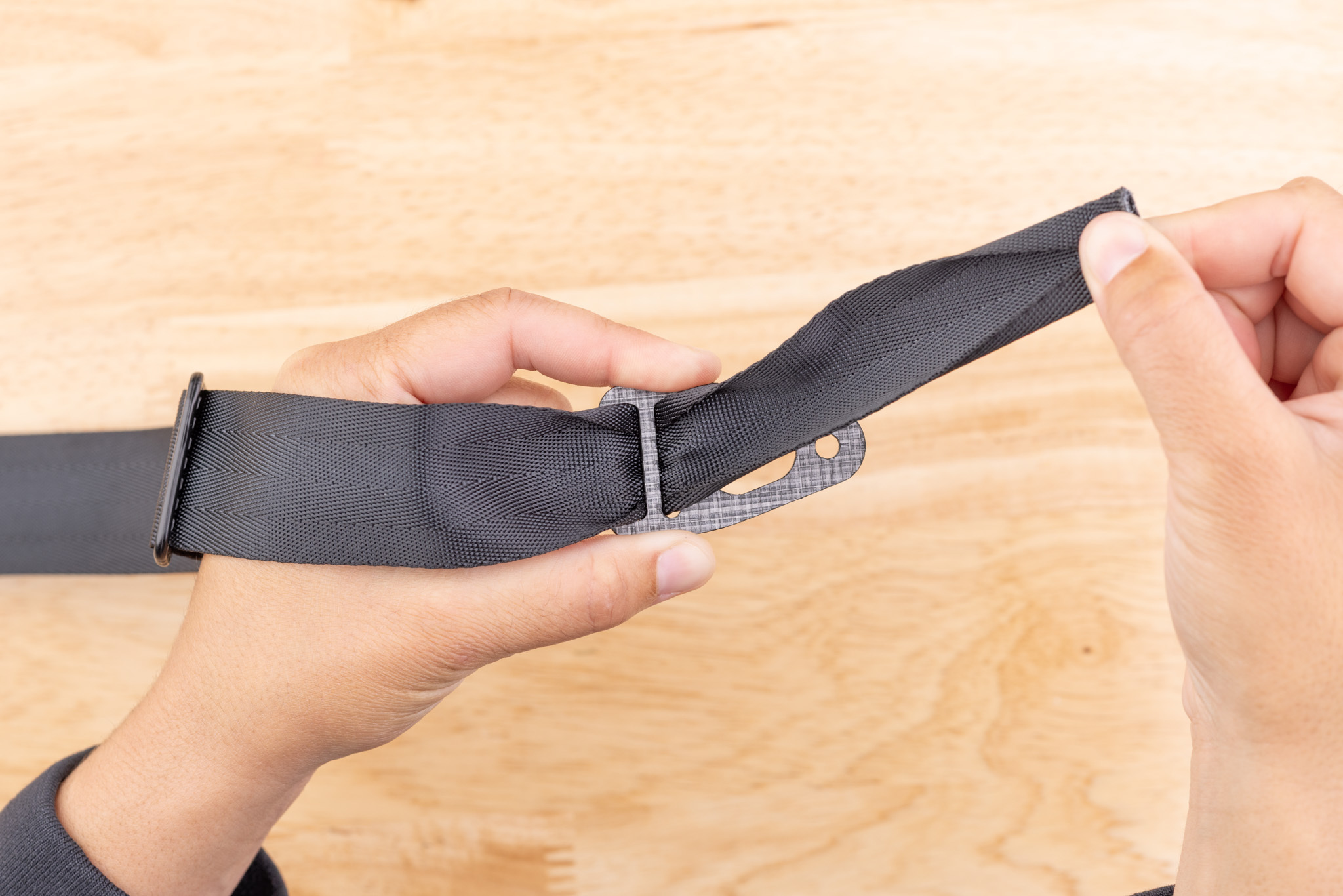 Photo of webbing being passed up through the inner slot of the Enigma belt end.