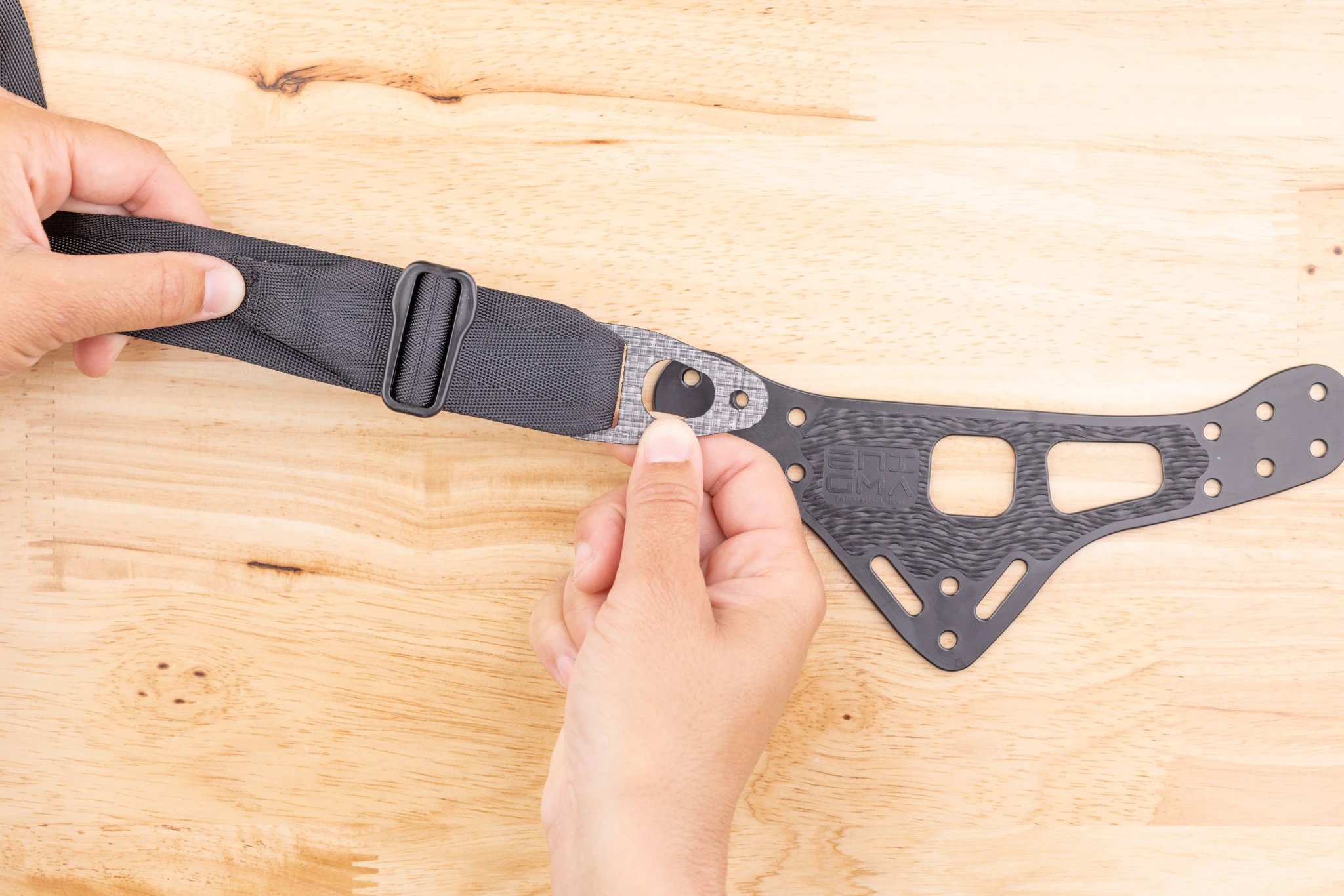 Photo of the Enigma belt end attached to the faceplate in the correct orientation, with the webbing passing over the top.