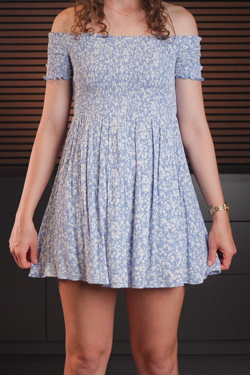 Blue floral A-line mini dress worn with a handgun concealed underneath, showing no visible printing.