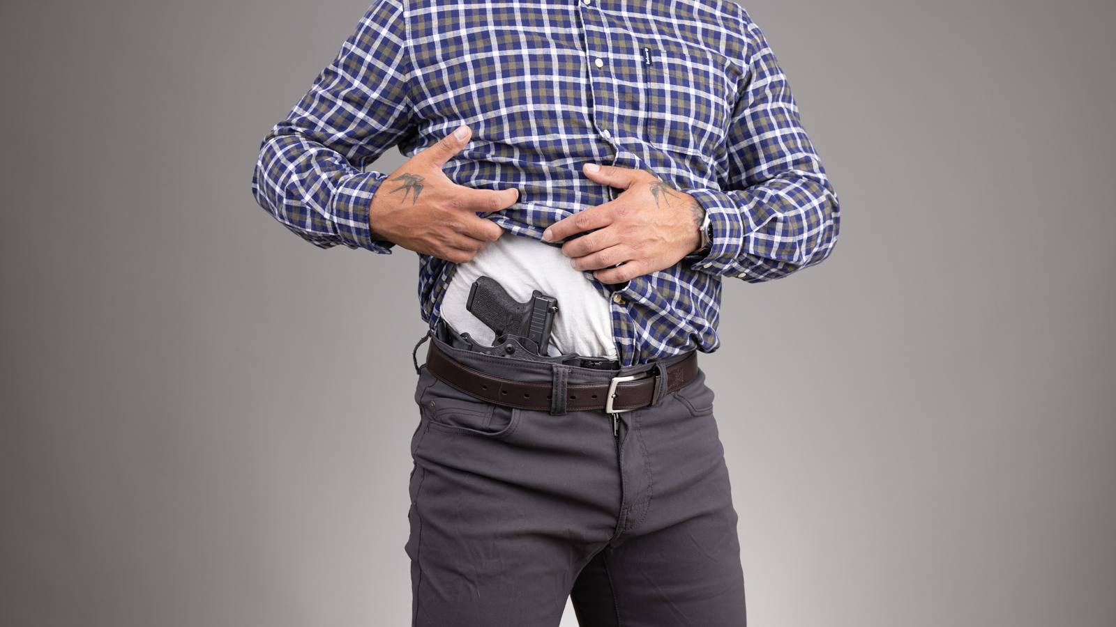 Man in business-casual attire carrying the PHLster Enigma Micro concealed