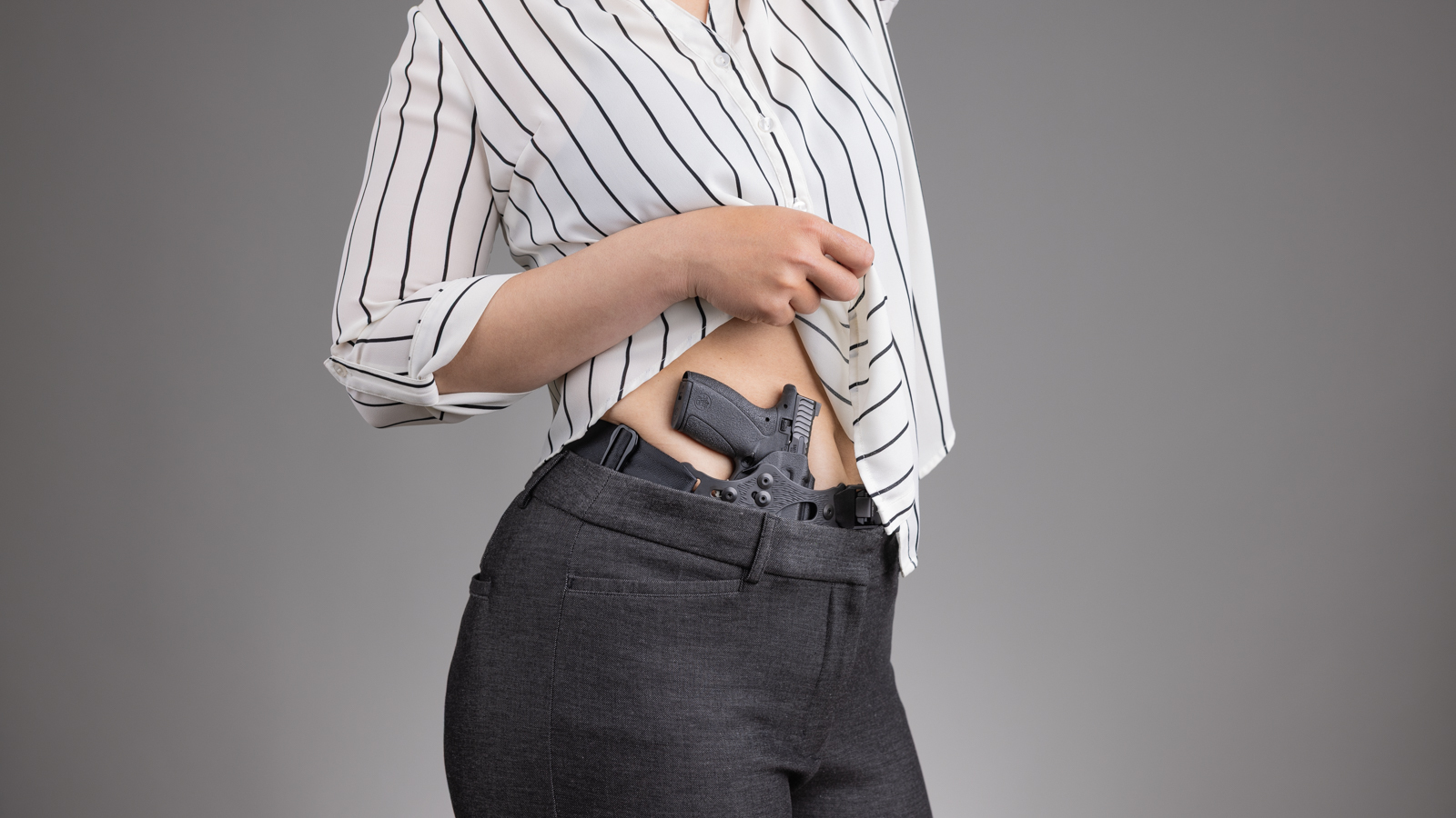 Woman in business-casual attire carrying the PHLster Enigma Micro concealed