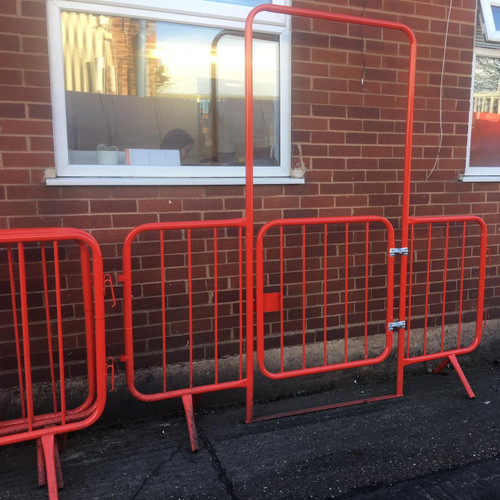 Oaklands 2.3m Spring Gated Walkthrough Site Access Barrier, a red metal safety gate installed outside a brick building for controlled access.