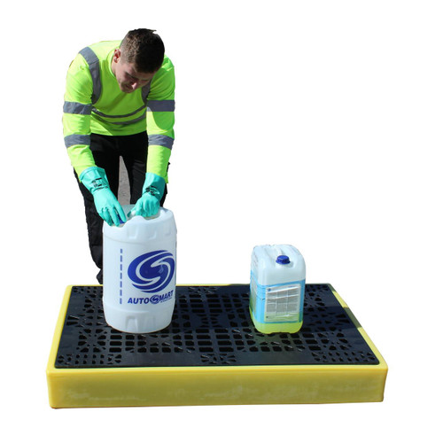 Romold BF2 Low Profile 2 Drum Bunded Workfloor 130ltr Sump, a sturdy black and yellow spill pallet with a metal grate surface, holding two containers and a person in high visibility jacket handling chemical drums.