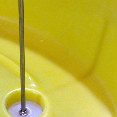 Romold Plug For BT75 Drum Tray & Debris Strainer, close-up of the yellow drum tray with a metal plug installed in the drainage hole.