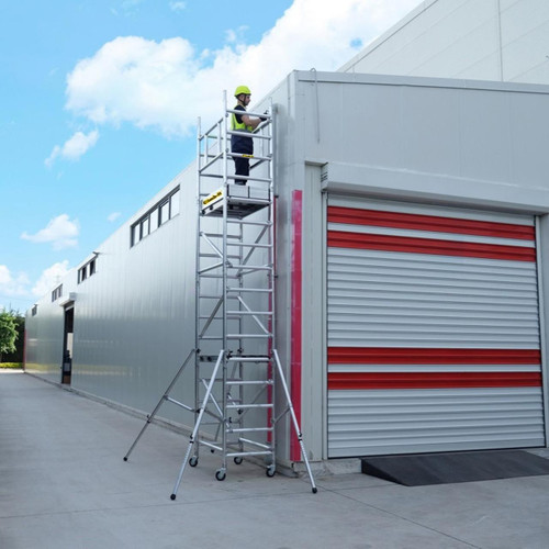 Climb IT GPC 1.2 to 3.6m Climb-It UniPro Scaffold Platform Tower, a worker using the mobile scaffold tower next to a building with red and white roller shutters.