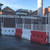 Oaklands GB2 Barrier Mesh Anti Climb Hoarding Panel, white metal fencing with safety barriers on a construction site.