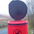 Melba Swintex 35L Doggy Waste Bin Post / Wall Mount, red dog waste disposal bin with black logo and black lid open, mounted outdoors on a pole.