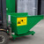 Emtez Construction Site Roll Forward Skip - CSRFS11, a green construction skip attached to a forklift with a yellow safety label and British-made sticker, used for debris collection at construction sites.