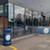 Roadware Derwent 120 Litre Outdoor Heritage Litter Bin, blue outdoor litter bin with Stockport County FC logo outside a modern building with glass windows.