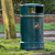 Roadware Derwent 120 Litre Outdoor Heritage Litter Bin, green outdoor trash receptacle with waste disposal symbol, designed for public parks and outdoor spaces.