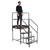 Climb IT GPC 1 to 3 Tread Climb-It Single Modular Platform, a person standing on a black metal multi-step climbing platform with stairs and safety railings.