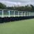 Site Supplies Mini Bison 1 Metre Water Filled Barrier 70kg, a black and white security barrier with water-filled base and metal panels, set up along a sports field.