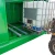 Emtez DPU64-16 64 Drum / 16 IBC Bunded Storage Cabinet, showing a large green metal storage cabinet with a forklift lifting an Intermediate Bulk Container (IBC) into it.