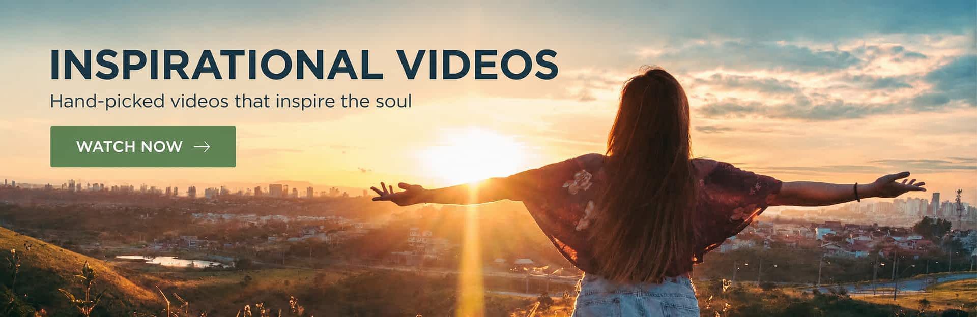 Woman with arms outstretched facing sunrise over city landscape